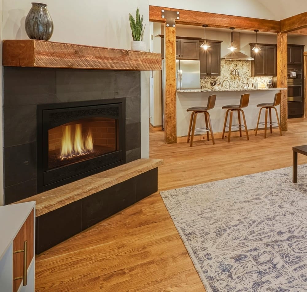 Warm mountain great room with a stone fireplace, reclaimed-wood beams, and an open kitchen, Pagosa Springs